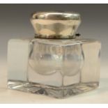 A large Edwardian silver mounted clear glass square desk inkwell, hinged cover, star-cut base,