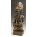 Tribal Art - a Yombe maternity figure, she sits, her infant laid across her lap,