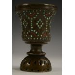 A Tibetan bronze chalice, chased with strapwork and applied with cabochons,