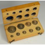 A set of brass scientific scale weights, from 100 to 1g, fitted beech case,