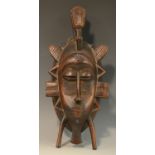 Tribal Art - a Baule mblo mask, scarified features,