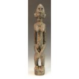 Tribal Art - an African figure, possiblry Senufo, Ivory Coast, she stands with knees bent,