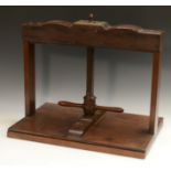 A George III mahogany library book press, shaped serpentine top rail, turned screw-thread,