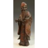 A Chinese rootwood figure, of a bearded immortal, he stands, wearing long robes, 32cm high,