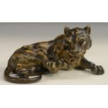 An Austrian cold painted bronze, of a lion cub, curled, with back paw raised for grooming,