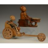 A Japanese Kobe automaton toy, as a comical figure in a carriage, the wheels animating his limbs,