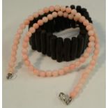 A pink coral bead necklace,