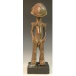 Tribal Art - an African figure, possibly Dogon, highly stylised with blank features,
