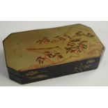 A Japanese export lacquer canted rectangular box, hinged cover decorated with a monumental lanscape,