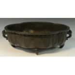 A Chinese dark patinated bronze lobed oval censer, cast with lappets, temple lion handles,