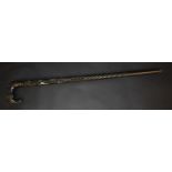 An Anglo-Indian/Ceylonese ebony walking cane, the curved L-shaped handle as the head of an elephant,