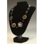 A banded agate necklace, composed of beads, sphreres and four bun-shaped panels, 45.