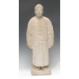 A Chinese marble figure, carved as a man in a traditional tunic and fur hat, rectangular base, 57.
