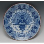 An 18th century Dutch Delft circular Peacock dish, typically painted in underglaze blue,