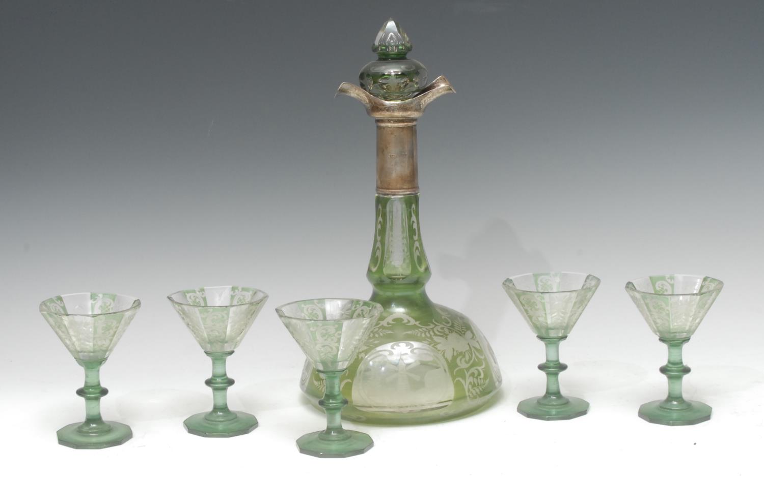 An early 20th century Bohemian green overlaid decanter and glasses,