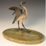 A late 19th century cold painted stork, a fish in its beak, onyx oval base,