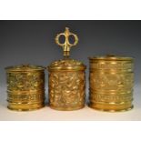 A late 19th century brass cylindrical string box, repousse embossed with scrolling acanthus,