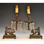 A pair of Regency dark-patinated bronze mantel lustres, boldly cast as a pair of hounds,