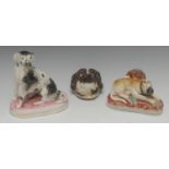 A Staffordshire model, of a seated hound, with black patch markings, oval base, washed in pink,