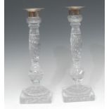 A pair of glass candlesticks, with plated nozzles and sconces, wrythen columns,