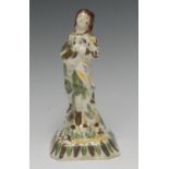 An 18th century Staffordshire creamware figure, of a boy standing holding a bird, flecked in green,