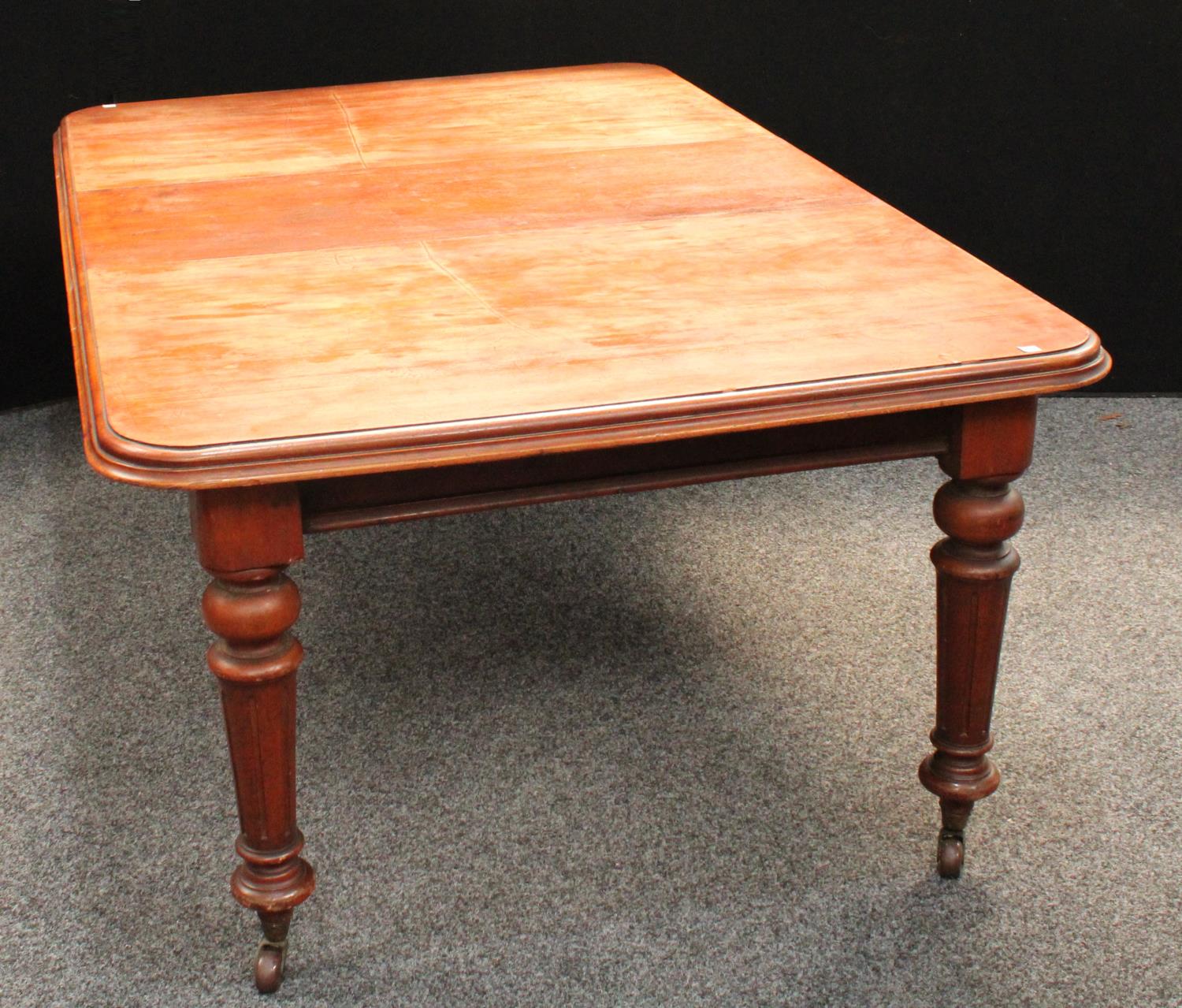 A Victorian mahogany extending dining table, rounded rectangular top with one additional leaf,