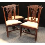 A set of four George III mahogany Chippendale design dining chairs,