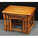 An Ercol elm nest of three occasional tables, the largest 62.