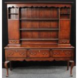 A large George III design oak dresser, open plate rack flanked by cupboards,