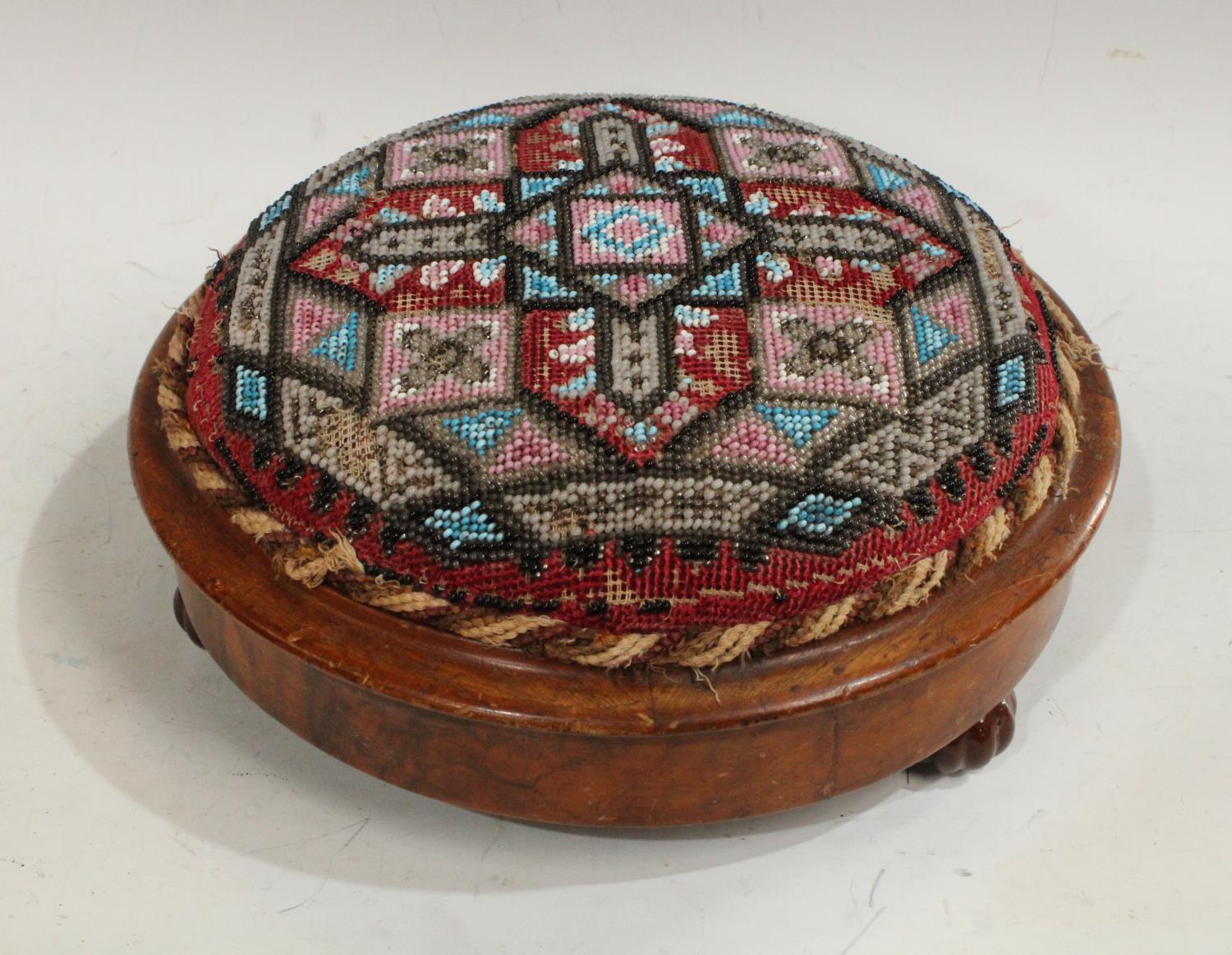 A Victorian walnut and beadwork circular footstool