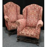 A pair of substantial George II style wing armchairs, of Spanish Baroque influence,