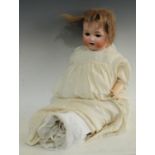 An Armand Marseille 990 socket head doll, sleeping brown eyes, open mouth with two teeth,