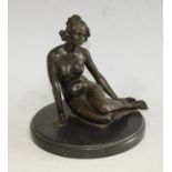 A dark patinated bronze nude, seated pensively legs to one side, her hair loosely tied,