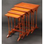 A set of George III style burr walnut quartetto tables, each plateau inlaid with a boxwood oval,