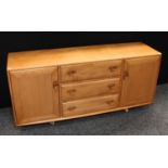 An Ercol elm sideboard, flush rectangular top above three central short drawers,