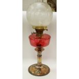 An Art Nouveaux oil lamp, red glass reservoir,