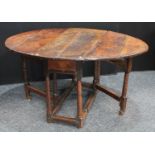 A '17th century' oak gateleg dining table, oval top with fall leaves above a frieze drawer,