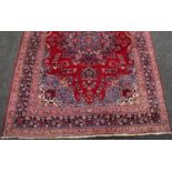 A Middle Eastern style carpet, woven throughout in traditional tones,