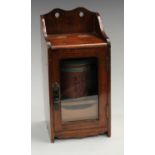 An oak tobacco cabinet and cylindrical tobacco jar; printed with comical anthropomorphic dogs,