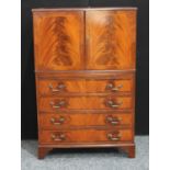 A flame mahogany tall boy, with a pair of doors above a slide and four long drawers,