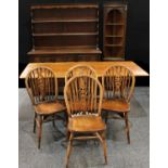 An oak refectory type trestle style dining table; a set of four wheel back dining chairs;