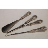 A George V set of three silver hafted lady's dressing table accessories, glove stretchers,