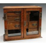 An Arts & Crafts oak smoking companion cabinet,