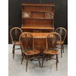 An oak drop leaf dining table; a set of four wheelback dining chairs;
