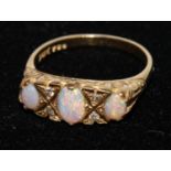 A 18ct gold opal and diamond ring, three oval opal cabochons, flashing green, violet,