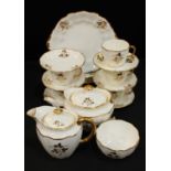 A Royal Crown Derby tea set applied with gold leafy stems on a white ground, comprising teapot,