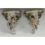 A pair of Sitzendorf wall brackets, moulded with cherubs,