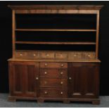 A Farmhouse pine dresser, outswept cornice above open shelves and six small drawers,
