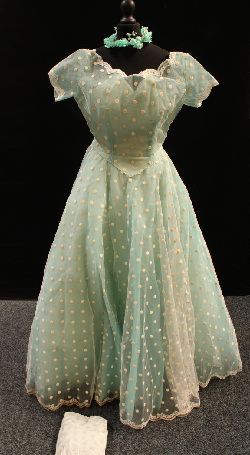 A mid 20th century evening gown and head dress, spotted cream net over turquoise underskirt,