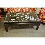 A Japanned coffee table inlaid with Abalone flora and fauna. 45cm high x 60.5cm wide x 120cm long.
